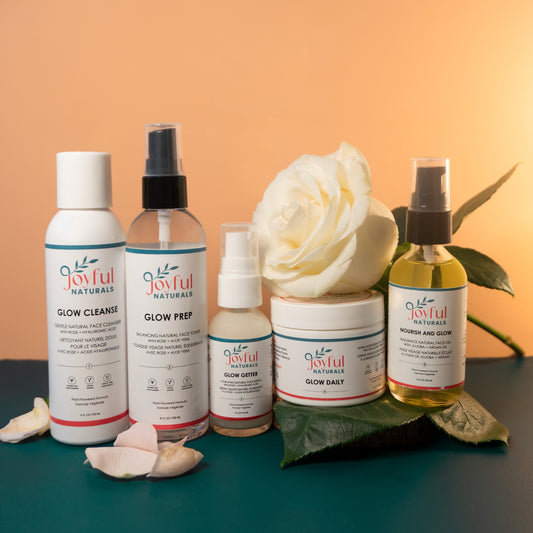 Joyful Naturals 5-piece skincare collection styled with botanicals for a total skin reset ritual.