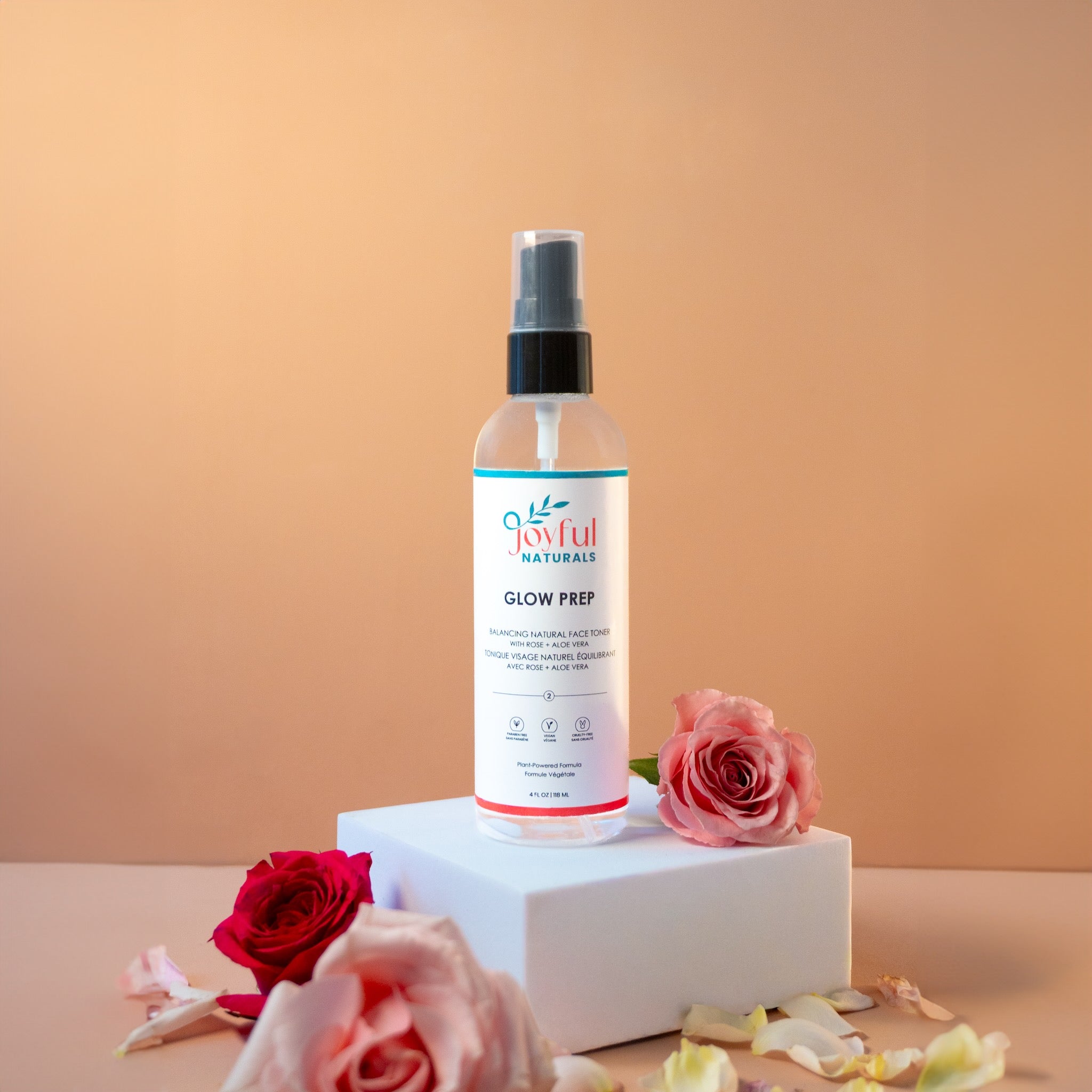 Rose water facial toner bottle styled with fresh rose flower to show natural ingredients.