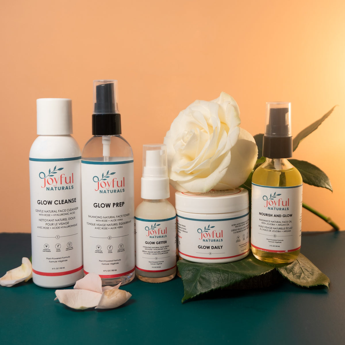 Joyful Naturals 5-piece skincare collection styled with botanicals for a total skin reset ritual.