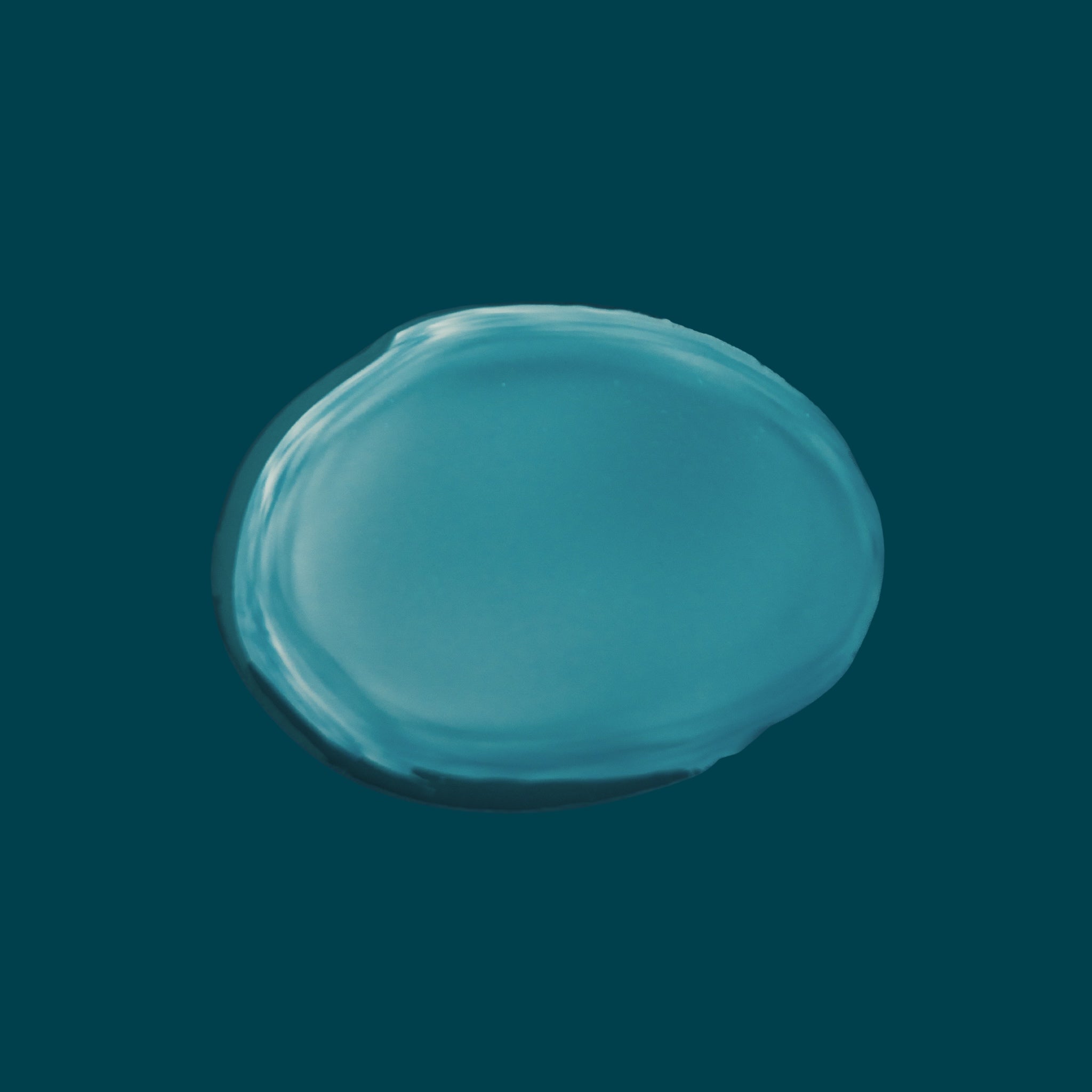 Lightweight non-greasy texture of Joyful Naturals jojoba face oil on teal background.